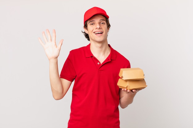 L'hamburger consegna l'uomo sorridente felicemente, agitando la mano, accogliendoti e salutandoti