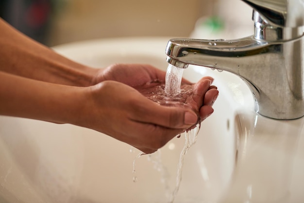 L'igiene inizia con le mani Primo piano di una donna irriconoscibile che si lava le mani in un bagno