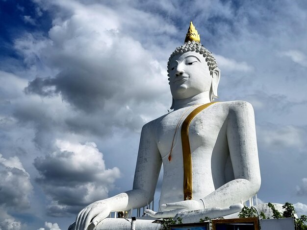 L'immagine del Buddha Kakusandha nell'atteggiamento di sottomettere Mara sulle nuvole sullo sfondo del cielo blu