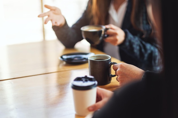 L'immagine del primo piano della gente si è divertita a parlare e a bere caffè insieme al bar