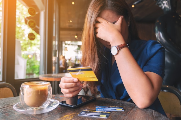 L'immagine del primo piano di una donna asiatica si stressa e si spezza mentre tiene la carta di credito