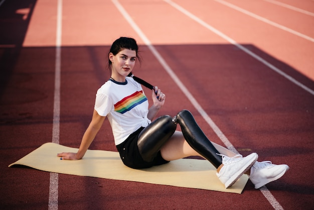 L'immagine della donna forte di sport disabili fa esercizi di stretching sportivo in palestra.