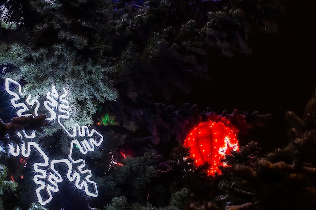 L'immagine di sfondo si illumina sotto forma di fiocchi di neve sull'abete