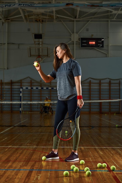 L'immagine di un giocatore di tennis di bella giovane donna di forma fisica di sport fa gli esercizi