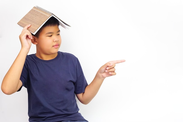 L'immagine di un ragazzo con gli occhiali indica di lato e si copre la testa con un libro. Concetto di educazione