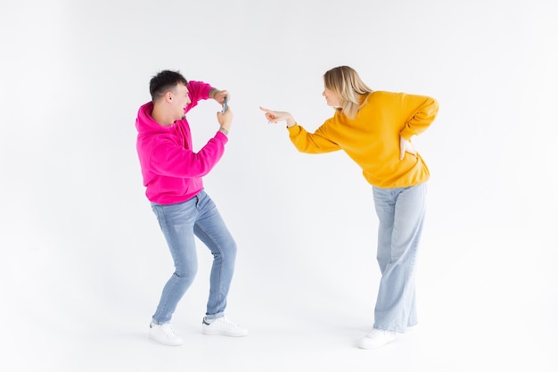 L'immagine di un uomo scatta una foto della sua donna ottimista positiva su sfondo bianco con il telefono cellulare