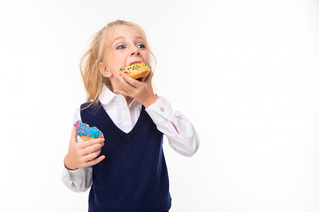 L'immagine di una bambina con i capelli biondi mangia ciambelle
