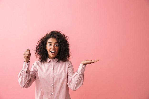 L'immagine di una bella giovane donna africana felice che posa copyspace mostrando isolato immagina che lei tiene l'ombrello.