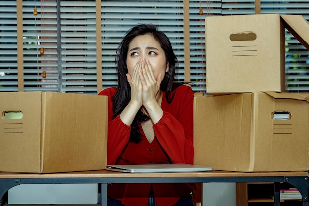 L'impiegato femminile seduto e piangendo si prepara tristemente per il nuovo lavoro Donna depressa al lavoro.