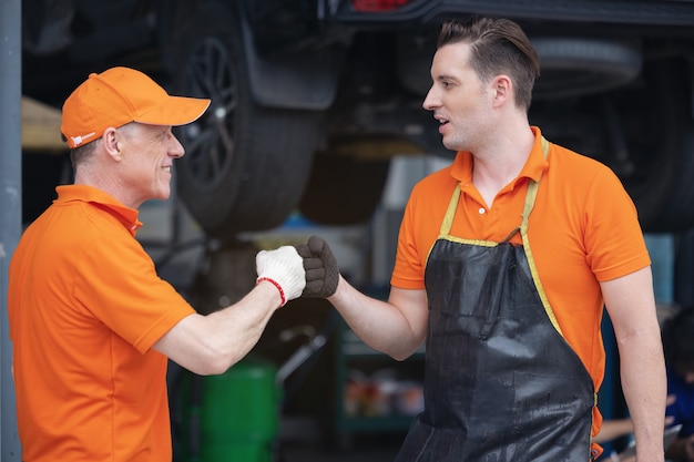 L'impiegato meccanico professionista della stretta di mano del servizio auto è d'accordo ed entrambi sembrano felici e soddisfatti