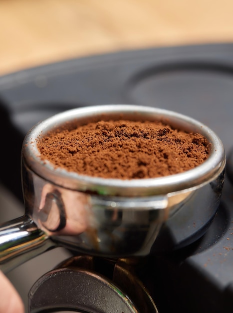 L'impiegato part-time della caffetteria dell'uomo asiatico prepara il caffè caldo nella macchina del caffè