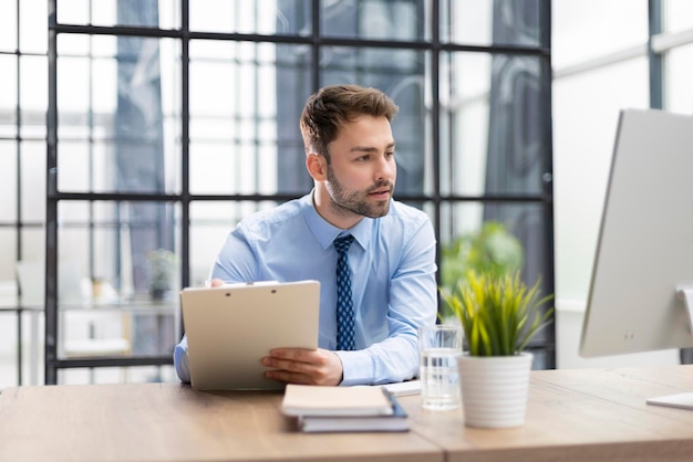 L'imprenditore di successo sta studiando i documenti con uno sguardo attento e concentrato