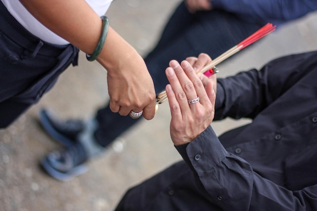 L'incenso in una mano dell'uomo viene sparato da un accendino sulla mano dell'altro.