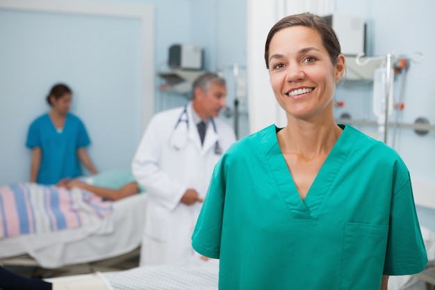 L&#39;infermiera è in piedi in una stanza d&#39;ospedale e sorridente