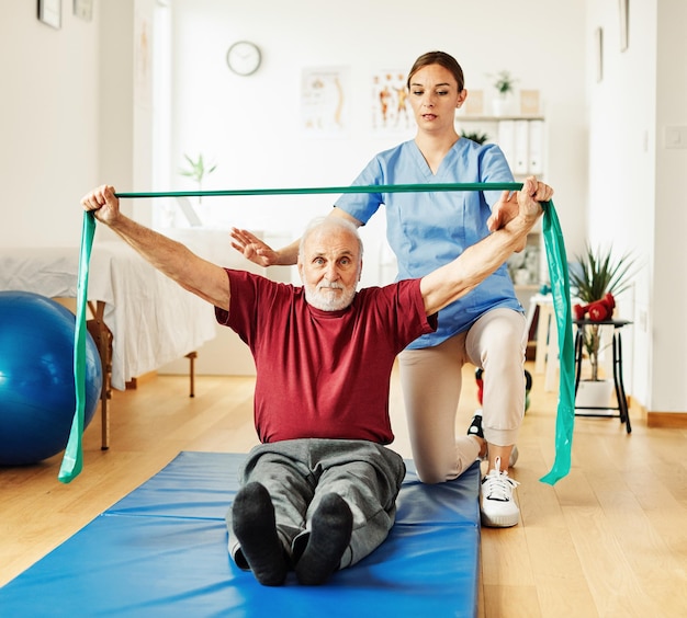 L'infermiere medico senior cura l'esercizio della terapia fisica che esercita l'aiuto all'assistenza al pensionamento