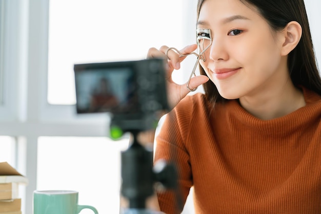 L'influenza dei capelli lunghi della bella donna asiatica mostra il passo del trucco vive sui social media con felicità e gioiosa