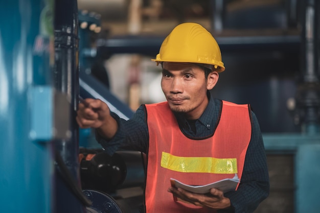 L'ingegnere asiatico sta lavorando in fabbrica e controllando il controllo del sistema di sicurezza sulla produzione industriale