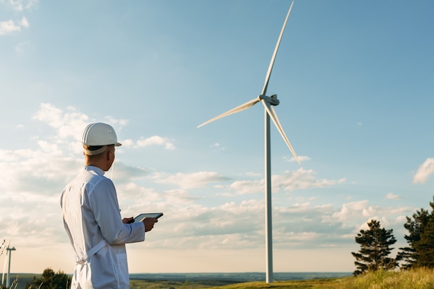 L'ingegnere controlla il sistema della turbina eolica con un tablet.