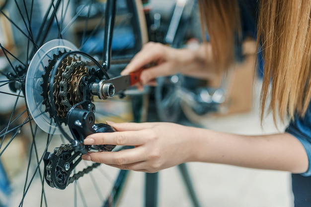 l&#39;ingegnere della bicicletta della donna sta riparando una bici nell&#39;officina