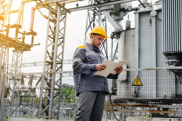 L'ingegnere energetico ispeziona l'attrezzatura della sottostazione. Ingegneria Energetica. Industria.