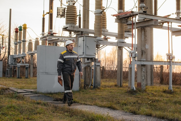 L'ingegnere energetico ispeziona le apparecchiature della sottostazione. Ingegneria Energetica. Industria