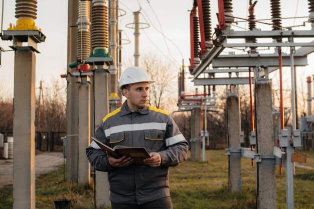 L'ingegnere energetico ispeziona le apparecchiature della sottostazione. Ingegneria Energetica. Industria