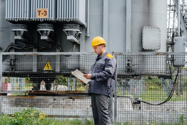 L'ingegnere energetico ispeziona le apparecchiature della sottostazione. Ingegneria Energetica. Industria.