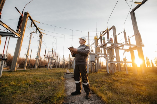 L'ingegnere energetico ispeziona le apparecchiature della sottostazione. Ingegneria Energetica. Industria