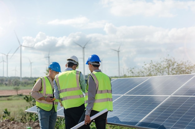 L'ingegnere ispeziona la costruzione del pannello solare o della cella fotovoltaica mediante dispositivo elettronico Energia rinnovabile industriale dell'operaio di fabbrica di energia verde che lavora sul tetto della torre