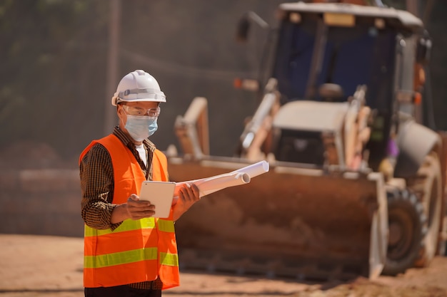 L'ingegnere maschio guardò il portatile e fece progetti per la costruzione della strada.