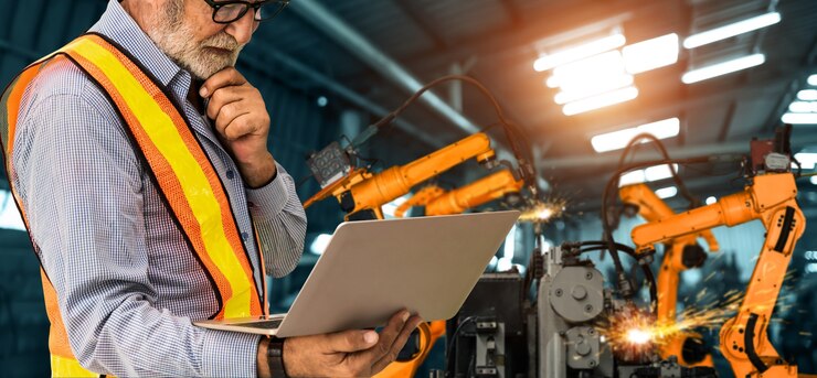 Foto l'ingegnere utilizza un software robotico avanzato per controllare il braccio robotico industriale in fabbrica