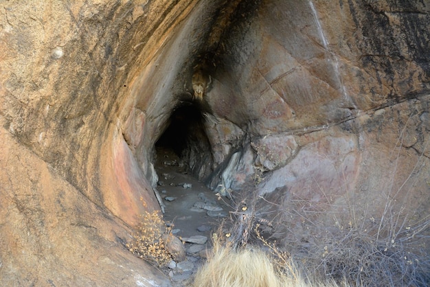 L'ingresso di una profonda grotta nella roccia è illuminato dal sole serale