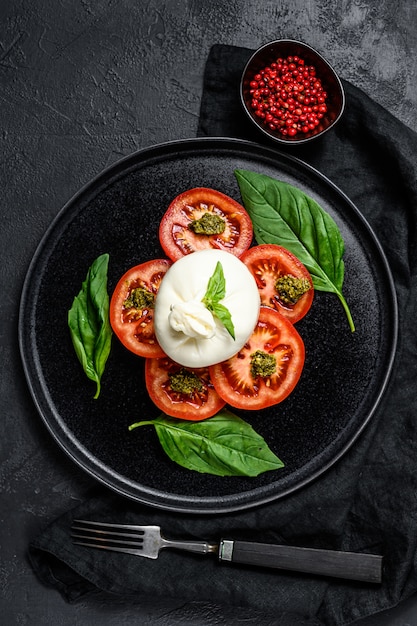 L'insalata del burrata e dei pomodori è servito sulla banda nera.