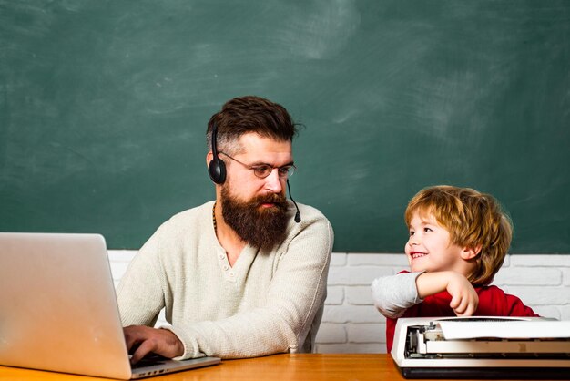 L'insegnante dell'uomo gioca con il bambino in età prescolare torna a scuola tutoraggio l'uomo insegna al bambino papà e figlio insieme