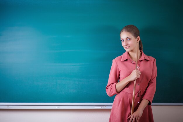 L'insegnante della giovane donna sta ad una lavagna con un puntatore.