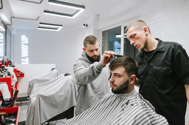 L'insegnante di parrucchiere insegna agli studenti a fare acconciature Barber Workshop Concetto di negozio di barbiere