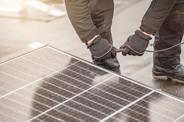 L'installatore del pannello solare collega i moduli insieme utilizzando un cavo elettrico o un supporto per filo spina