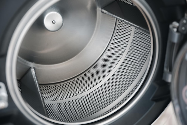 L'interno della vasca della lavatrice è realizzato in acciaio inossidabile Primo piano di un nuovissimo elettrodomestico in metallo con materiale del tamburo
