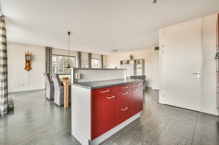 Foto l'interno di un appartamento spazioso con una zona pranzo di design aperta e una piccola cucina nei toni del rosso