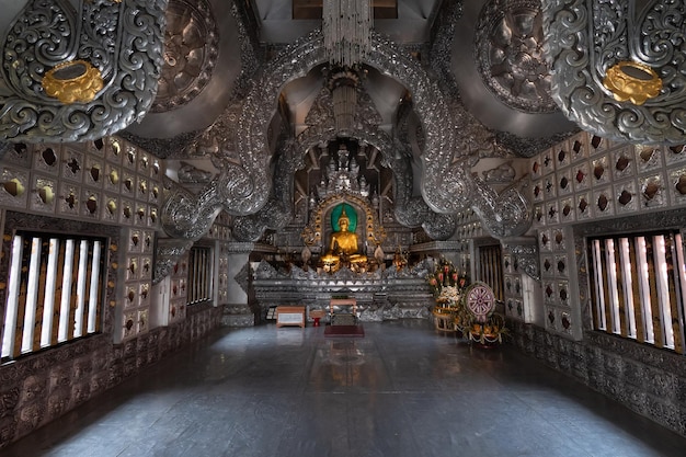 L'interno di un tempio con un grande soffitto d'argento e una statua di Buddha.