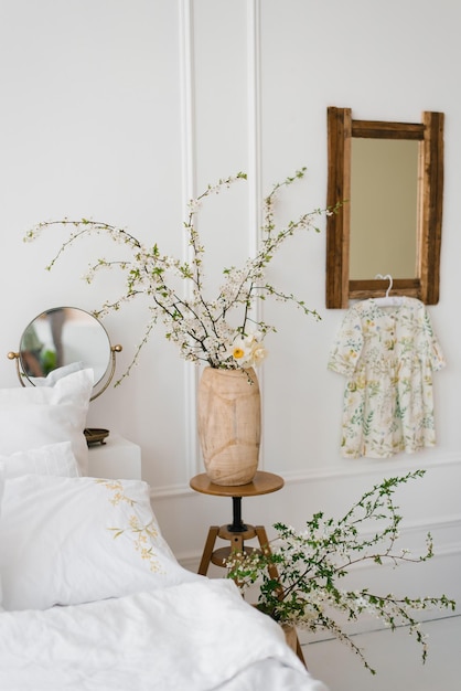 L'interno di una bella camera da letto bianca moderna con fiori primaverili