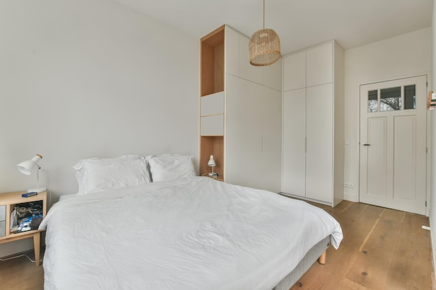 L'interno di una camera da letto con un grande letto in un design bianco in una casa moderna