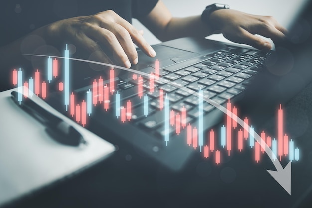 L'investitore analizza il grafico azionario con le previsioni dell'uomo d'affari del laptop e il grafico di analisi