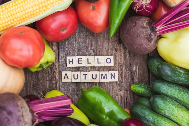 L'iscrizione ciao autunno sullo sfondo di verdure fresche di fattoria umore autunnale e cibo autunnale