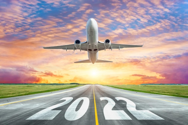 L'iscrizione sulla superficie della pista 2022 della pista dell'aeroporto con il decollo dell'aereo Concetto di viaggio durante le vacanze di capodanno