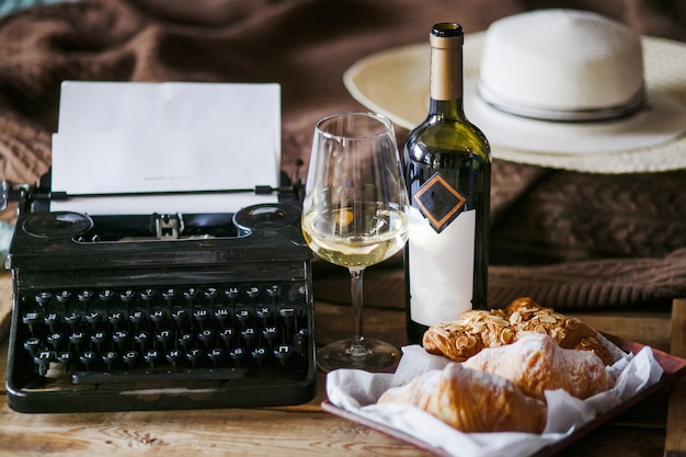 L'ispirazione di uno scrittore che scrive testi su una macchina da scrivere vintage freelance colazione croissant e wine office in stile loft