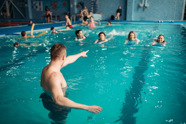 L'istruttore lavora con la classe in piscina