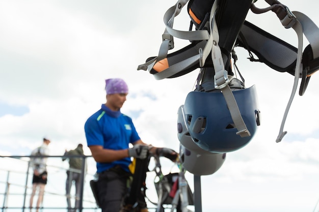 L'istruttore maschio allegro prepara una corda e un'attrezzatura prima di saltare da una scogliera Ropejumping