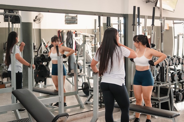 L'istruttrice di palestra e il suo studente parlano mentre riposano tra una serie e l'altra