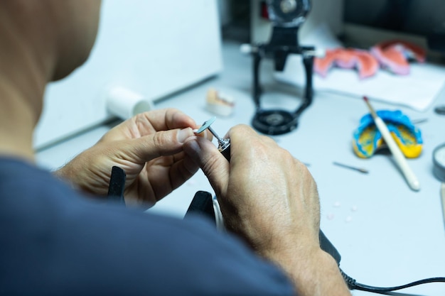 L'odontotecnico lavora nel suo laboratorio e produce denti artificiali per il primo piano dell'odontoiatria